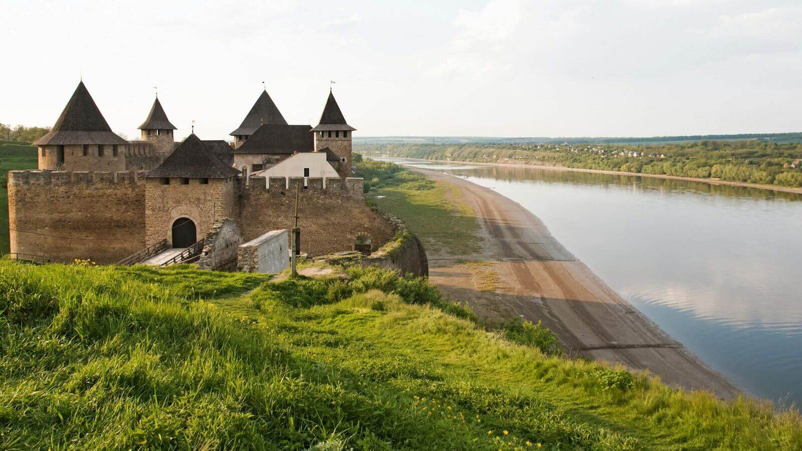 Stone-walled medieval fortress on a green hill above the Dniester river valley. Stone-walled medieval fortress on a green hill above the Dniester river valley.